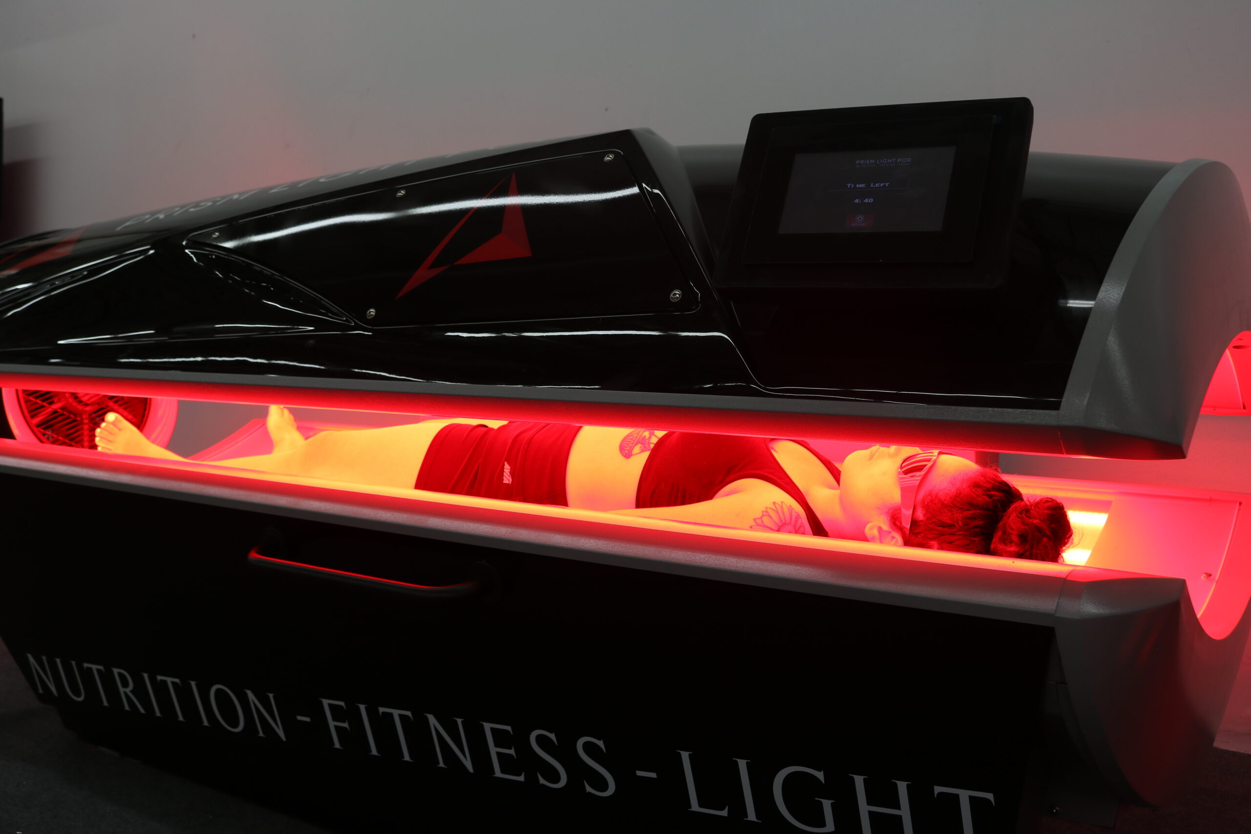 Client relaxing inside the Prism Light Pod during a full-body photobiomodulation session at Nobility Performance in Ottawa